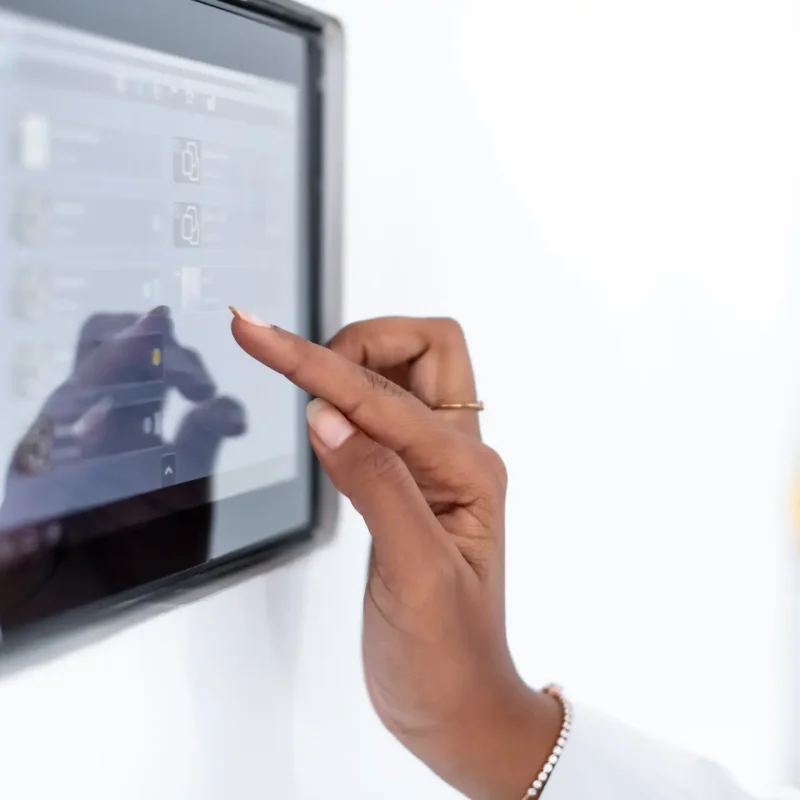 Person bedient ein Touchpanel zur Nutzung digitaler Systeme